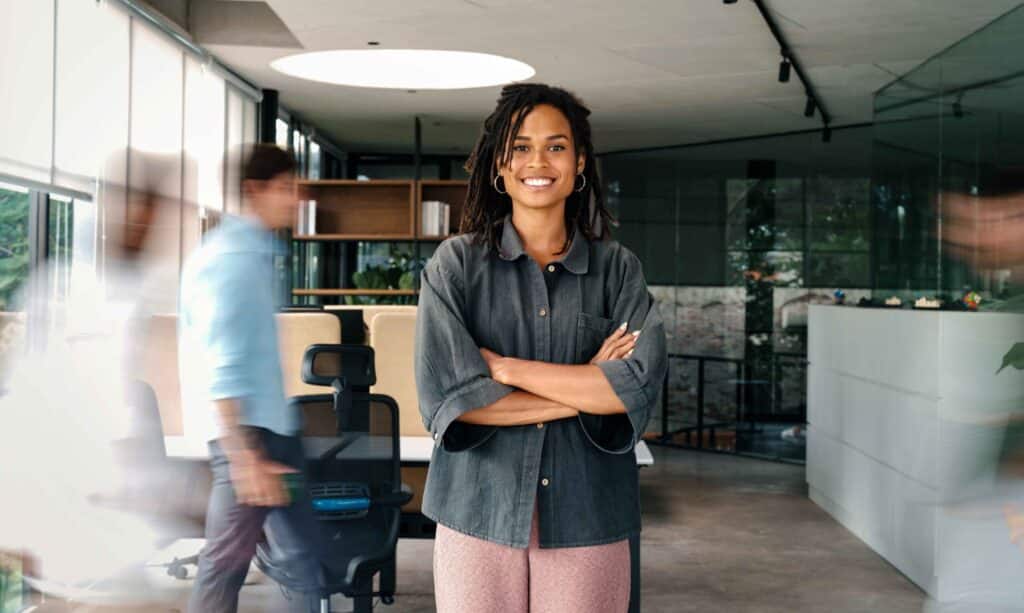 Jeune professionnelle confiante dans un environnement de bureau moderne, illustrant un profil prêt à intégrer l’entreprise